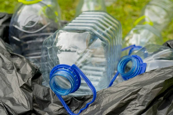 Άδεια Πλαστικά Μπουκάλια Που Βρίσκονται Σακούλα Σκουπιδιών Στο Γρασίδι — Φωτογραφία Αρχείου