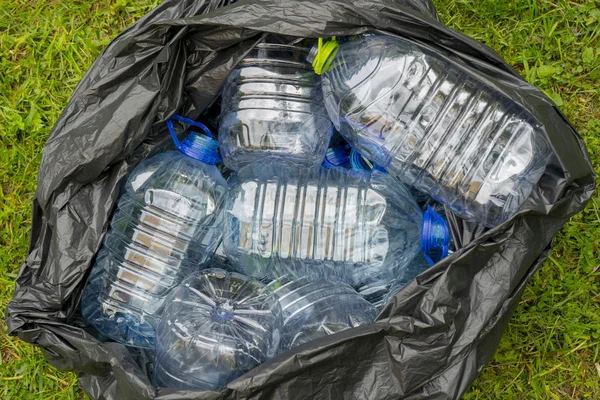 Çöp Torbasında Çimenlerin Üzerinde Yatan Boş Plastik Şişeler — Stok fotoğraf