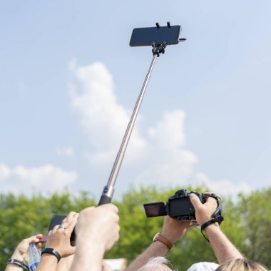 Akıllı telefon gökyüzüne karşı erkek elinde bir selfie sopa