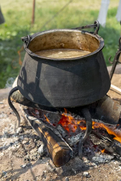 Food is cooked in a pot on the fire