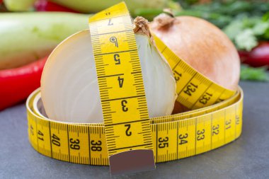 Çevreyi ölçmek için şerit çekiliyor. Diyet pişirmek için sebzeler