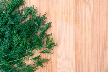 Ahşap mutfak masasında taze yeşil dereotu. Bahçe bitkisi..