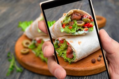 Sebzeli taze ekmek ve akıllı telefon ekranında et. Yemek pişirmek..