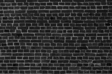 Tasarım ve çeşitli sahneler için veya video röportajları için arka plan olarak eski siyah tuğla duvarın arka planı.