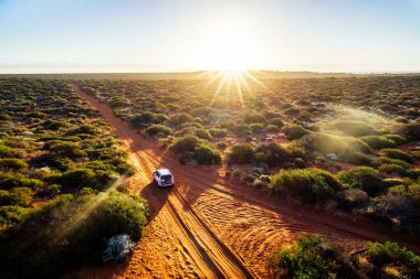 Road trip in Australia, aerial view of a car off road at sunset. Francois Peron National Park clipart