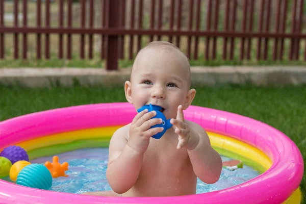 A small child is bathing in a pool, inflatable children's inflatable pool in summer