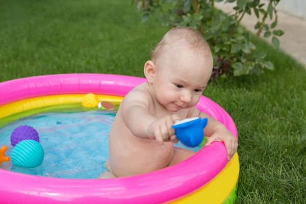 A small child is bathing in a pool, inflatable children\'s inflatable pool in summer