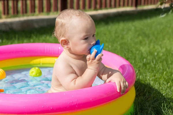 A small child is bathing in a pool, inflatable children's inflatable pool in summer