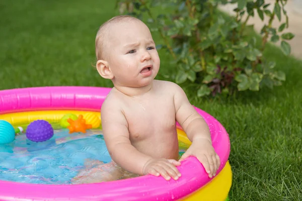 A small child is bathing in a pool, inflatable children\'s inflatable pool in summer