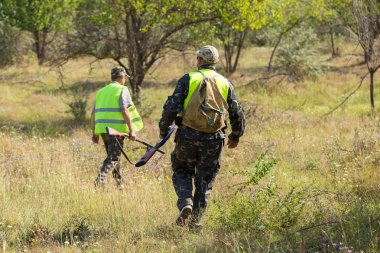Bir Alman drathaar ve İspanyol, köpeklerle ava güvercin ile avcılar