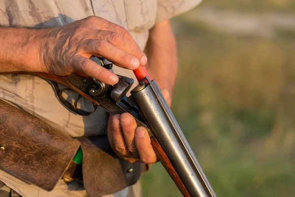 Charges a hunting smooth-bore rifle, hunting a pheasant with dogs