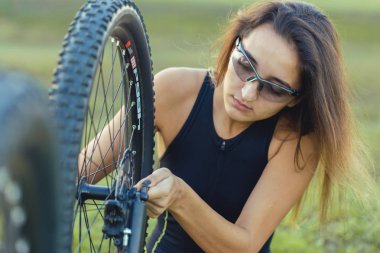 Kız bir dağ bisikleti offroad, güzel günbatımı, adlı bir bisikletçi portresi üzerinde açık Fitness kız bir modern karbon fiber dağ bisikleti sürmek..