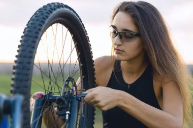 Kız bir dağ bisikleti offroad, güzel günbatımı, adlı bir bisikletçi portresi üzerinde açık Fitness kız bir modern karbon fiber dağ bisikleti sürmek..