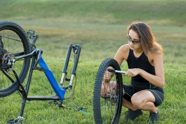 Kız bir dağ bisikleti offroad, güzel günbatımı, adlı bir bisikletçi portresi üzerinde açık Fitness kız bir modern karbon fiber dağ bisikleti sürmek..