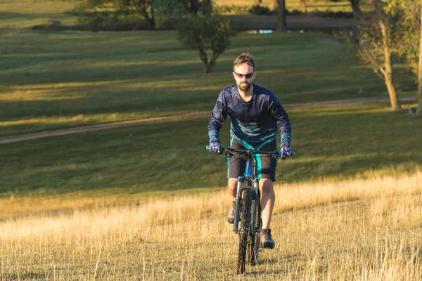 Cyclist in shorts and jersey on a modern carbon hardtail bike with an air suspension fork