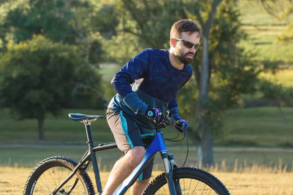 Cyclist in shorts and jersey on a modern carbon hardtail bike with an air suspension fork