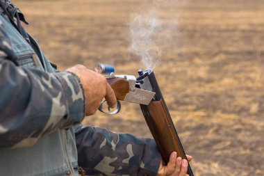 Avcı bir şapka ve bozkır, avını bulmak için silah reloads silah, silah varil duman
