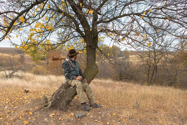 猎人带着帽子和枪在草原上寻找猎物 瞄准猎物 — 图库照片