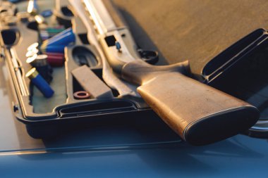 Adam silahlı kartuşları doğada vuruyor, avcı hedefe günbatımında vuruyor.