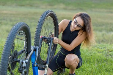 Kız bir dağ bisikleti offroad, güzel günbatımı, adlı bir bisikletçi portresi üzerinde açık Fitness kız bir modern karbon fiber dağ bisikleti sürmek..