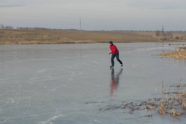 Adam donmuş gölde buz pateni yapıyor