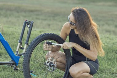 Kız bir dağ bisikleti offroad, güzel günbatımı, adlı bir bisikletçi portresi üzerinde açık Fitness kız bir modern karbon fiber dağ bisikleti sürmek..