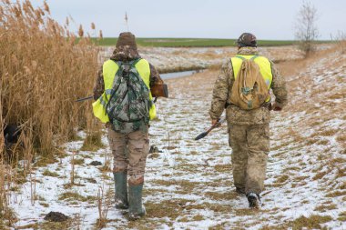 Male hunters with shotgun hunting outdoors