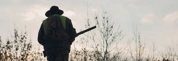 총으로 사냥꾼의 실루엣입니다 위장에 대초원에 조끼와 모자에 사냥꾼 — 스톡 사진