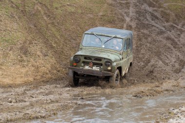 Bir SUV kir ve su tekerleklerin altında dışarı rips. Yakın çekim tüm arazi aracı.