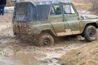 Bir SUV kir ve su tekerleklerin altında dışarı rips. Yakın çekim tüm arazi aracı.