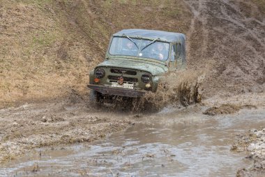 Bir SUV kir ve su tekerleklerin altında dışarı rips. Yakın çekim tüm arazi aracı.