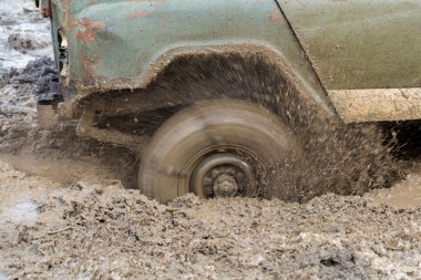 Bir SUV kir ve su tekerleklerin altında dışarı rips. Yakın çekim tüm arazi aracı.