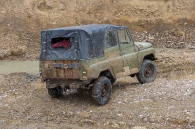 Bir SUV kir ve su tekerleklerin altında dışarı rips. Yakın çekim tüm arazi aracı.