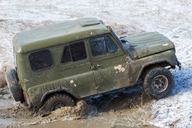 Bir SUV kir ve su tekerleklerin altında dışarı rips. Yakın çekim tüm arazi aracı.