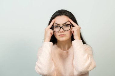 Mutlu genç beyaz kadın olarak pembe bir jumper. Bir kızla el eylem gri bir arka plan üzerinde duygusal portresi. Kavramsal iş saplama.