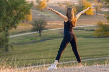 Doğada yoga yaparken genç güzel kız.