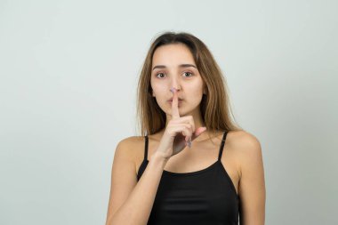 Young caucasian girl with silence sign on white background 