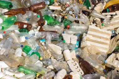 Çöp sahasında plastik torbalar ve şişeler. İzinsiz çöp salınımı, doğanın kirliliği. Çevre felaketi kavramı.