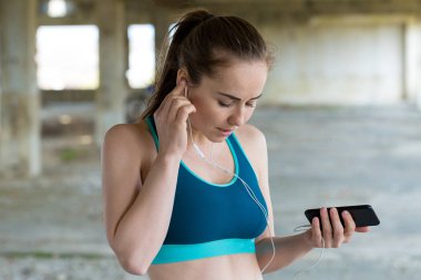 Egzersiz yaptıktan sonra menekşe yoga veya fitness mat tutan çekici genç kadın. Bir su şişesi tutar.