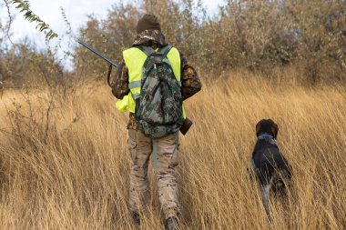 Male hunter with shotgun hunting outdoors