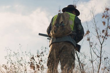 Açık havada av tüfekli bir erkek avcısı.