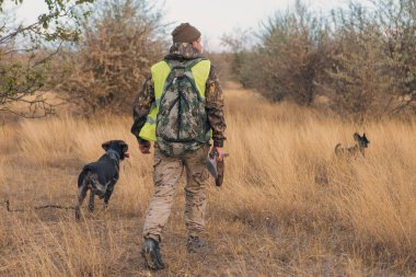 Male hunter with shotgun hunting outdoors