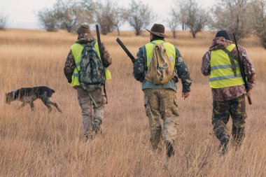 Male hunters with shotgun hunting outdoors