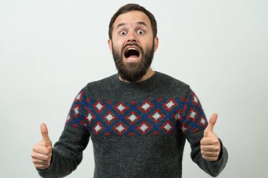 Heyecanlı sakallı beyaz adam beyaz arka planda baş parmak gösteriyor.  