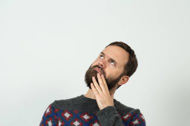 Beyaz arka planda düşünceli, sakallı, beyaz bir adam.     