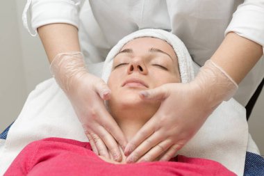 Yüz bakımı. Güzellik uzmanı güzellik salonunda fırça kullanarak yüzüne güzellik maskesi takıyor.