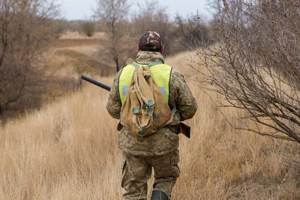 stock image Hunter with a hat and a gun in search of prey in the steppe, Aims for prey