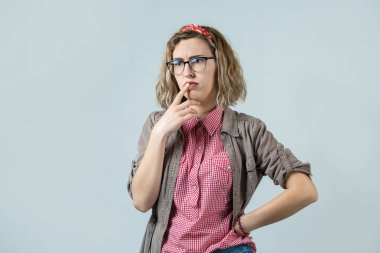 Düşünceli, genç, sarışın, beyaz arka planda gözlük takan beyaz bir kız.