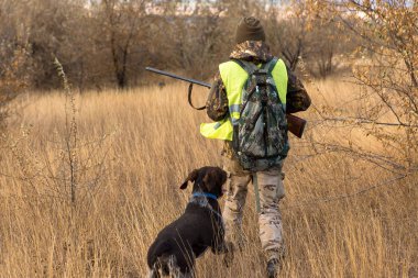 Male hunter with rifle hunting outdoors