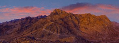 Gün doğumunda görünür sis ile siluet dağ sırası. Uçsuz bucaksız çölün güzel dağları.